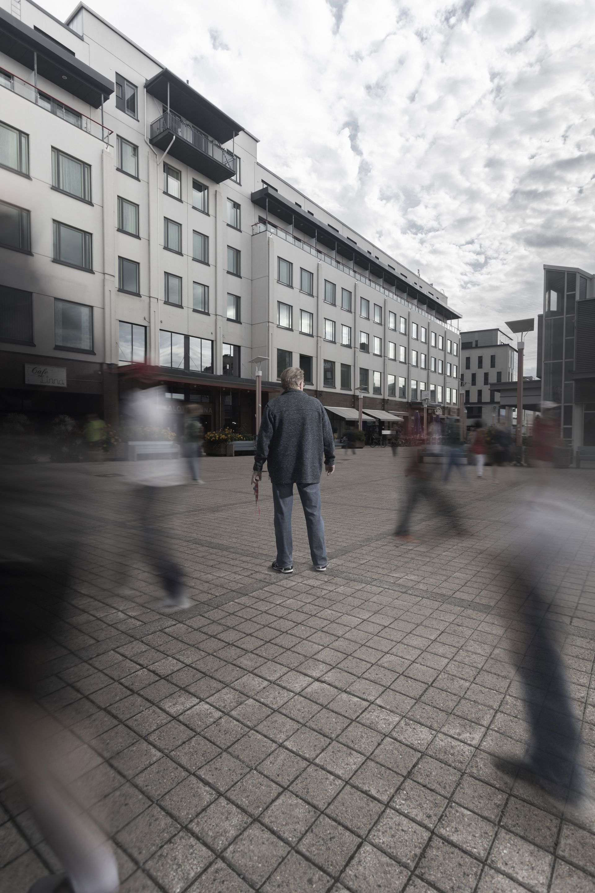 A person stands in a market square holding a Red Cross key chain.