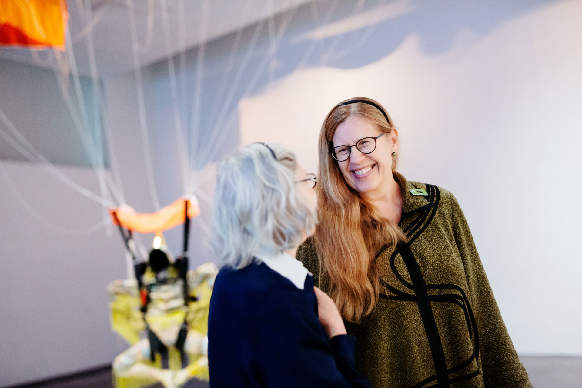 Smiling Elvi Immonen and Mervi Virtanen discussing at Kiasma.