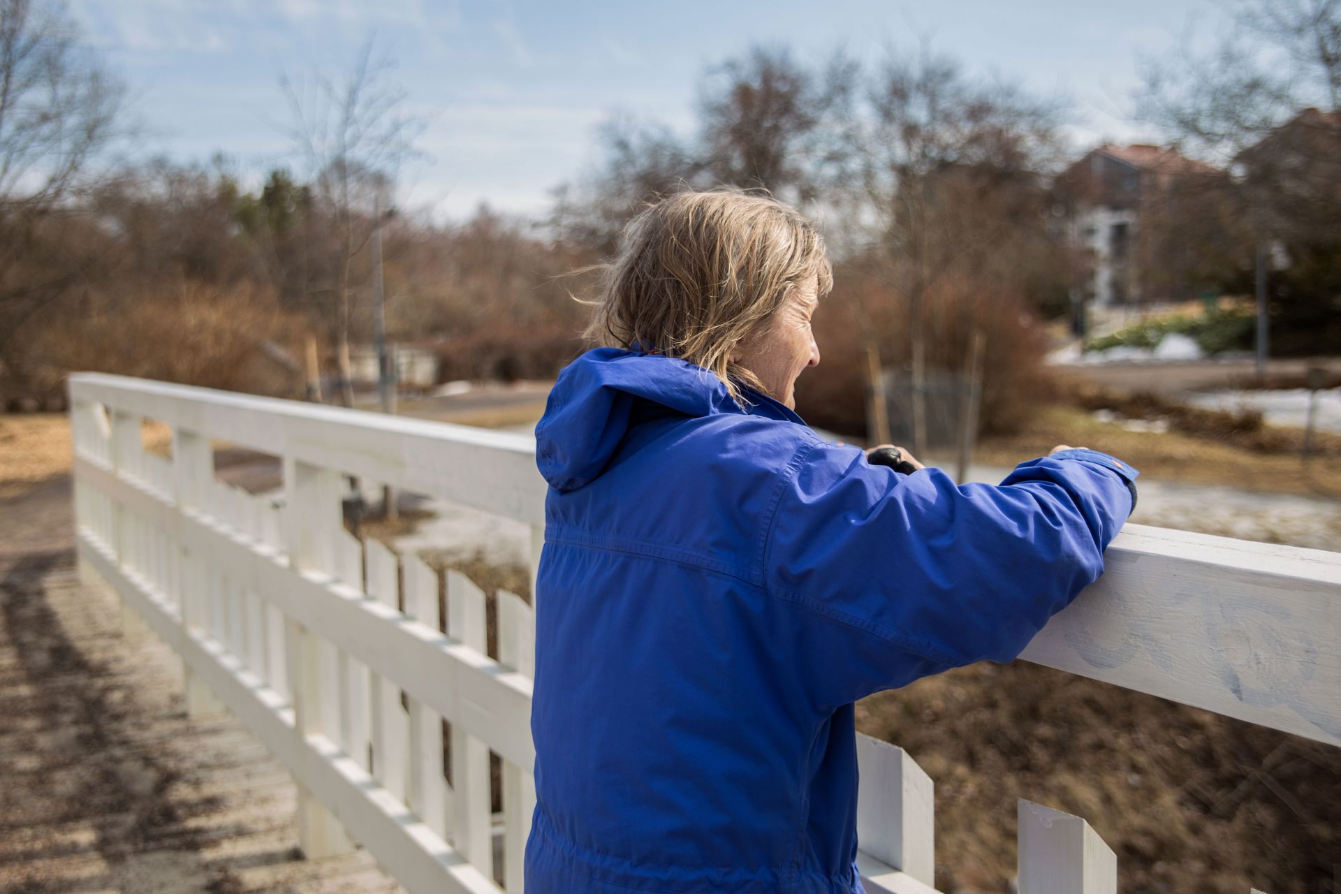 A person leaning on a bridge and looking ahead.