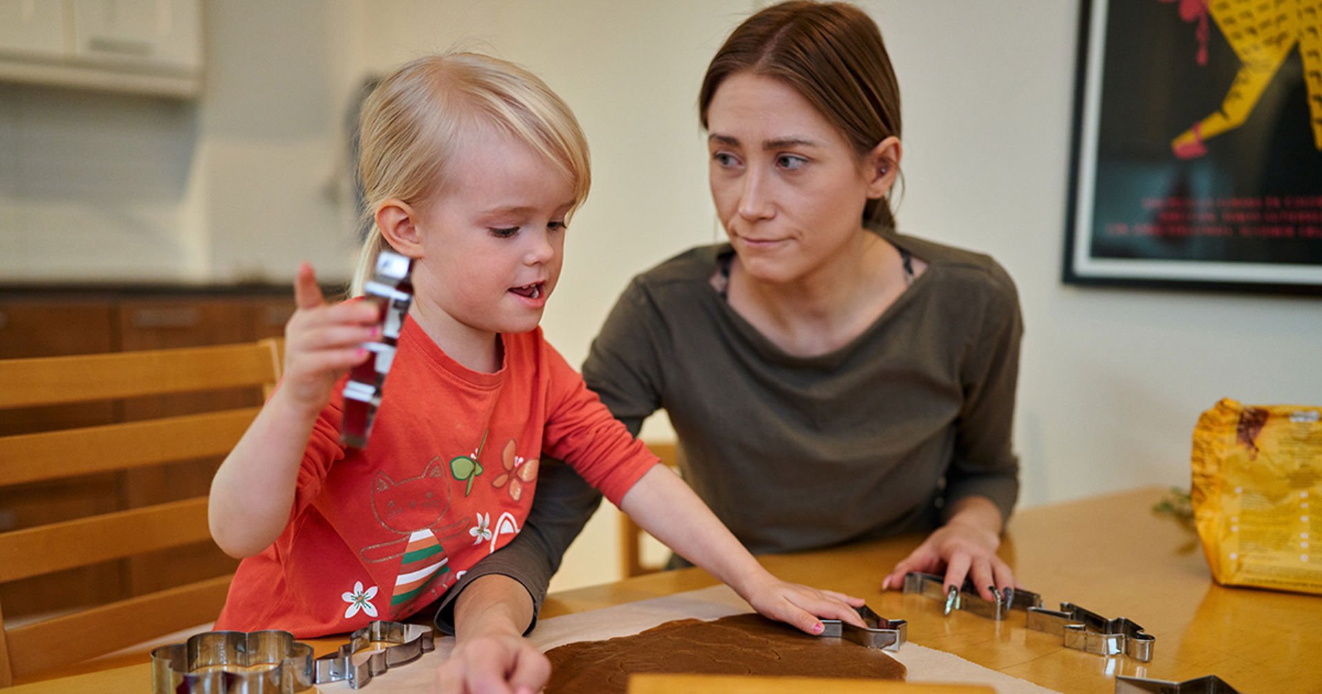 A mother bakes Christmas cookies in the kitchen with her child.