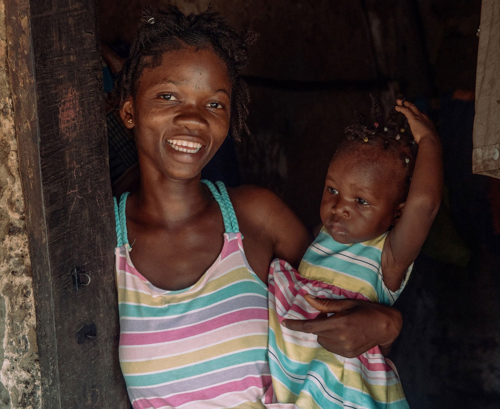 A smiling Hawanatu is holding her daughter Mariama.