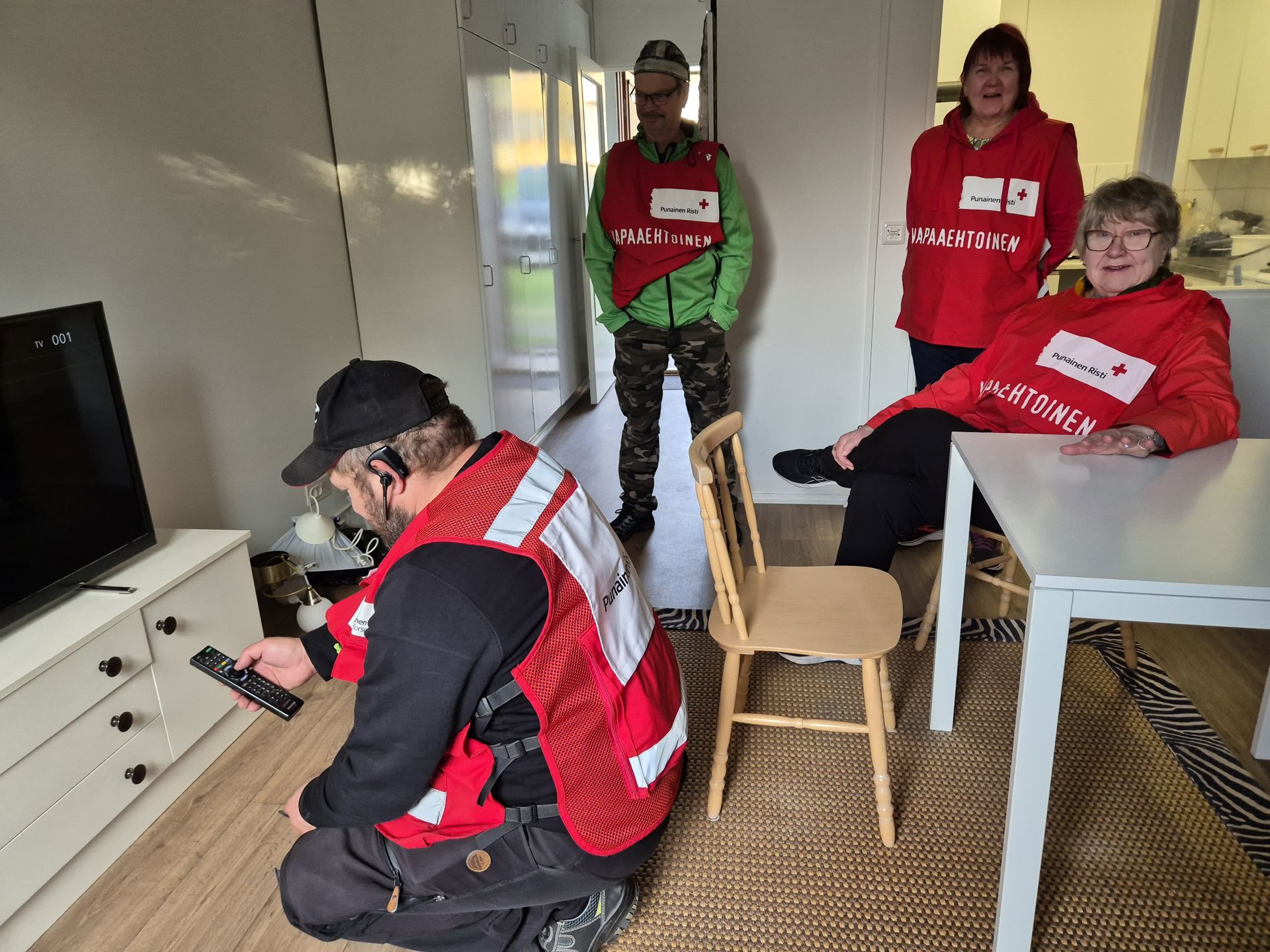 Four Red Cross volunteers are helping to furnish an apartment.