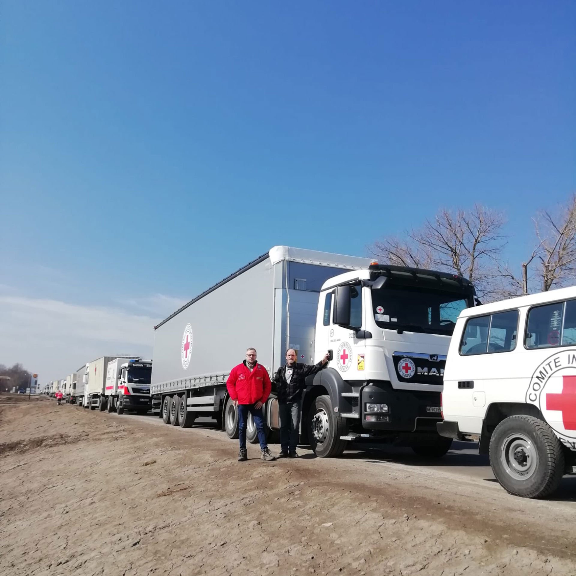 Ari Mäntyvaara and Jari Kymäläinen standing next to the first truck of the convoy.