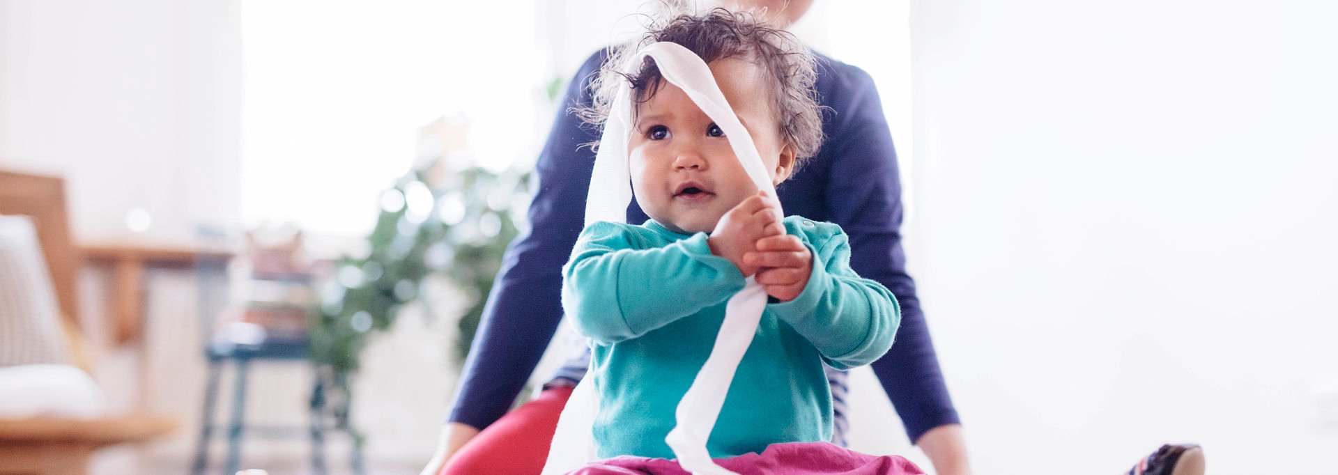 A small child playing with dressing gauze.