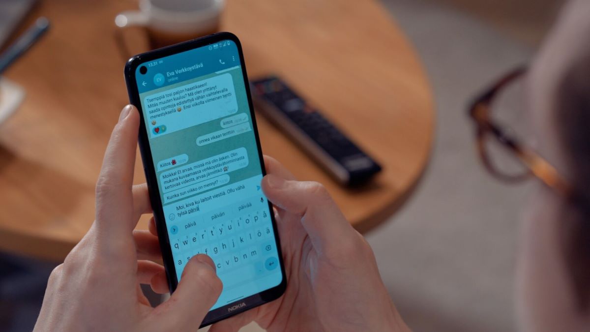 A close-up of a person and a phone screen with an open chat conversation.