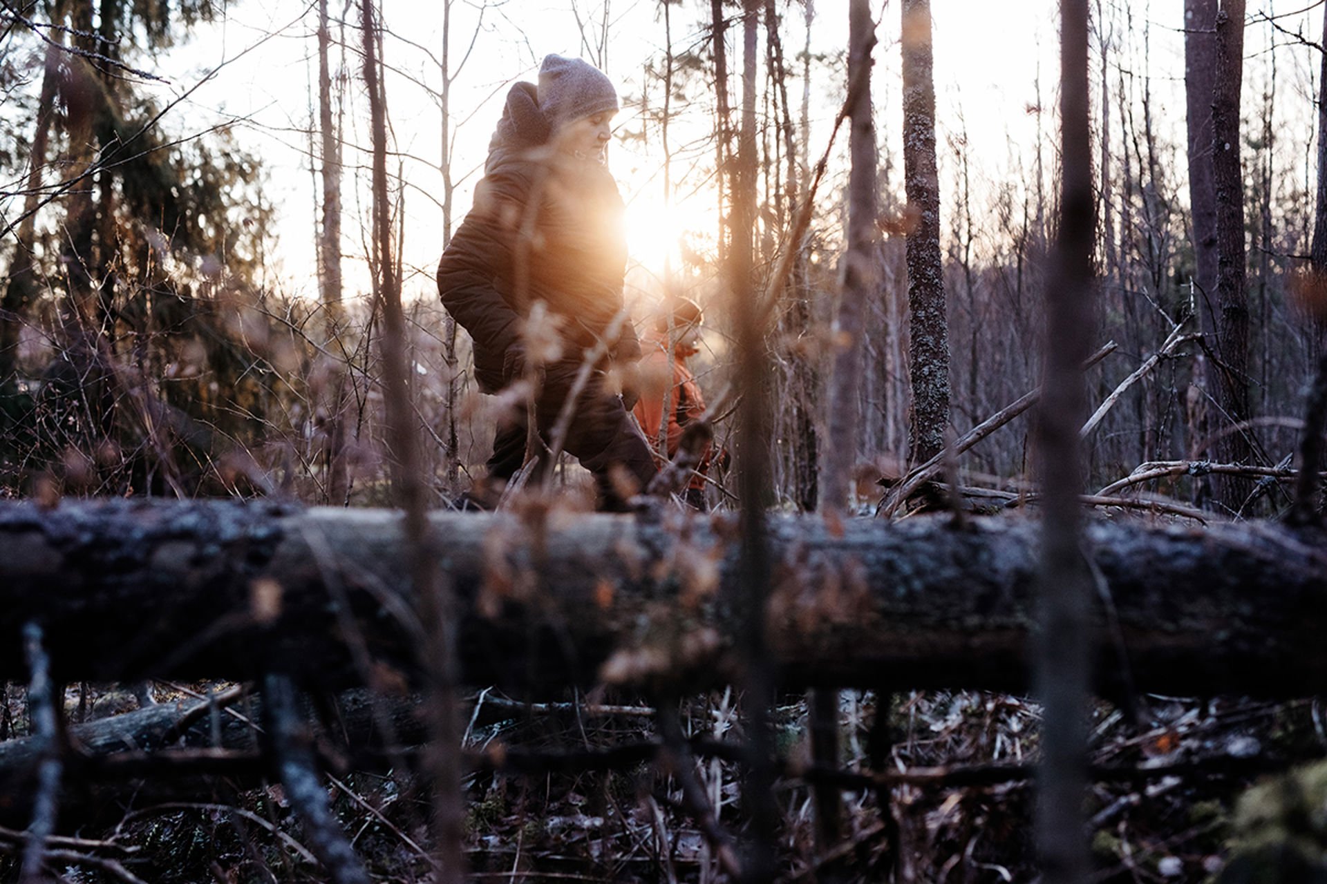 A man and a woman participating in the search and rescue activities of the Voluntary Rescue Service in a sunny forest in the winter.