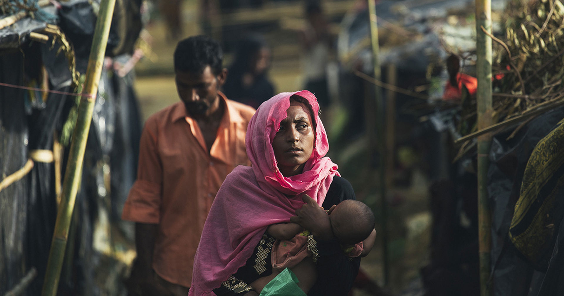 A woman carrying a baby in her arms.