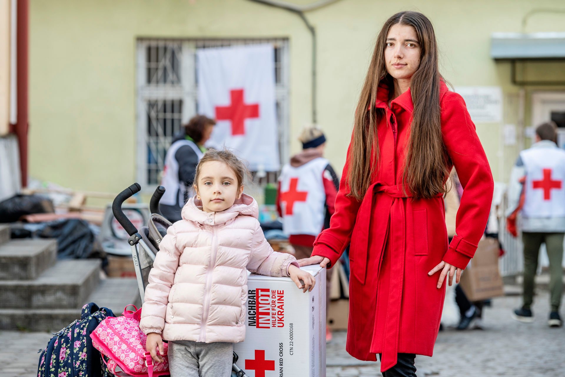 A mother and daughter standing next to each other.