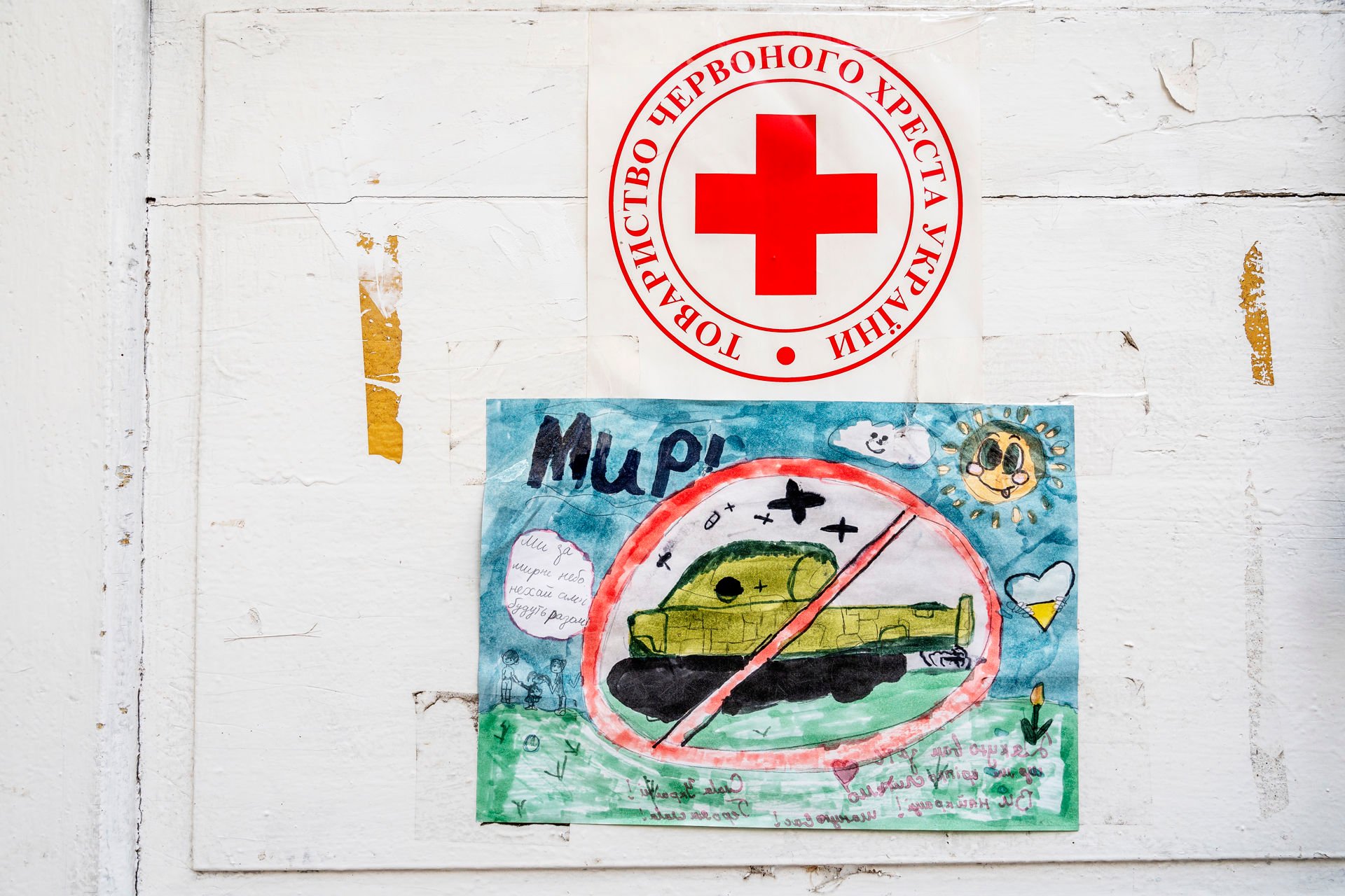 A child’s drawing of a tank. There is a Red Cross logo above the tank.