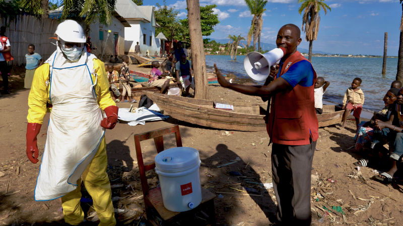 Volunteers wear Ebola protection suits to dispel rumours