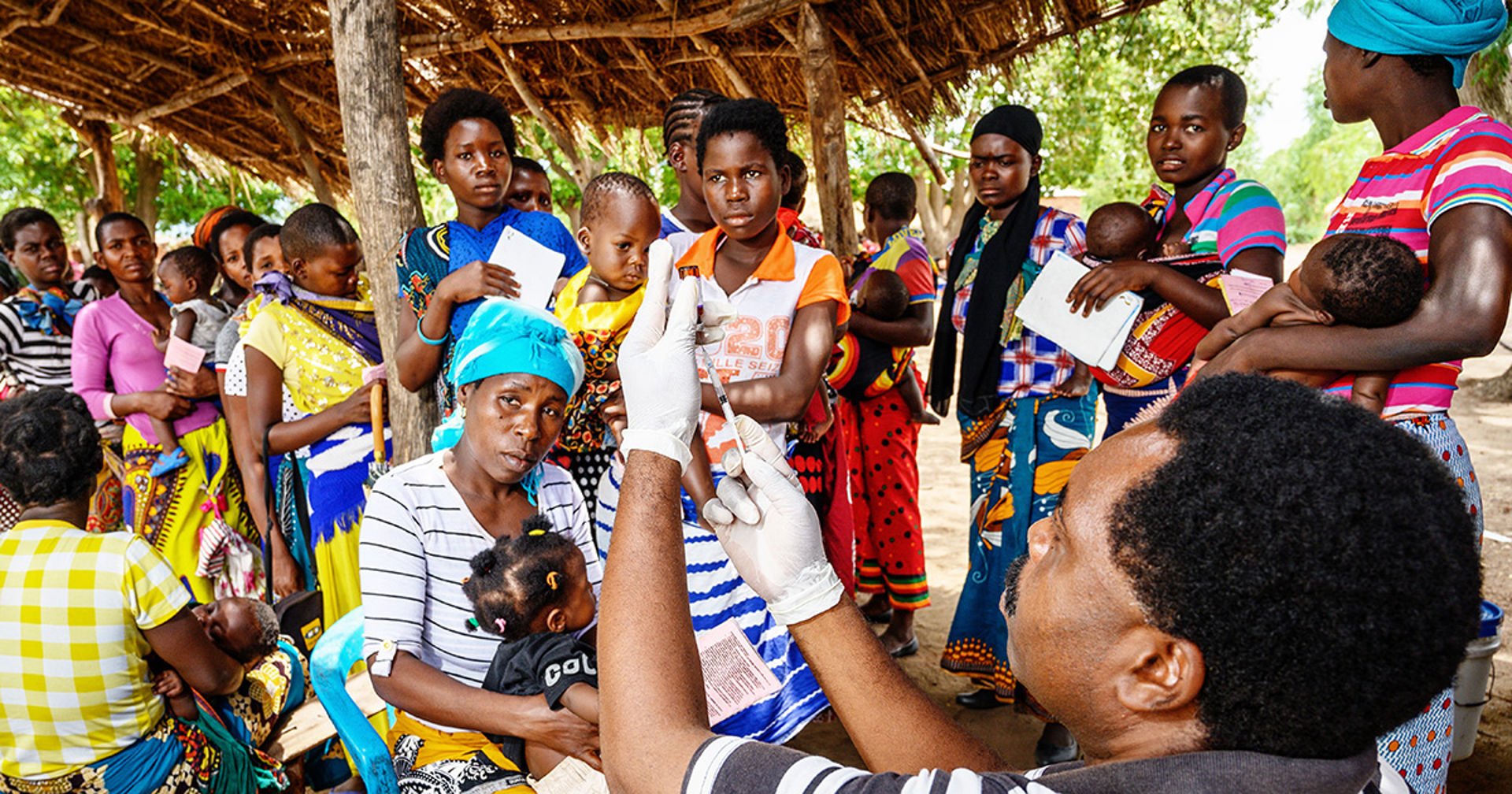 Dozens of African mothers and small children visiting the health clinic.