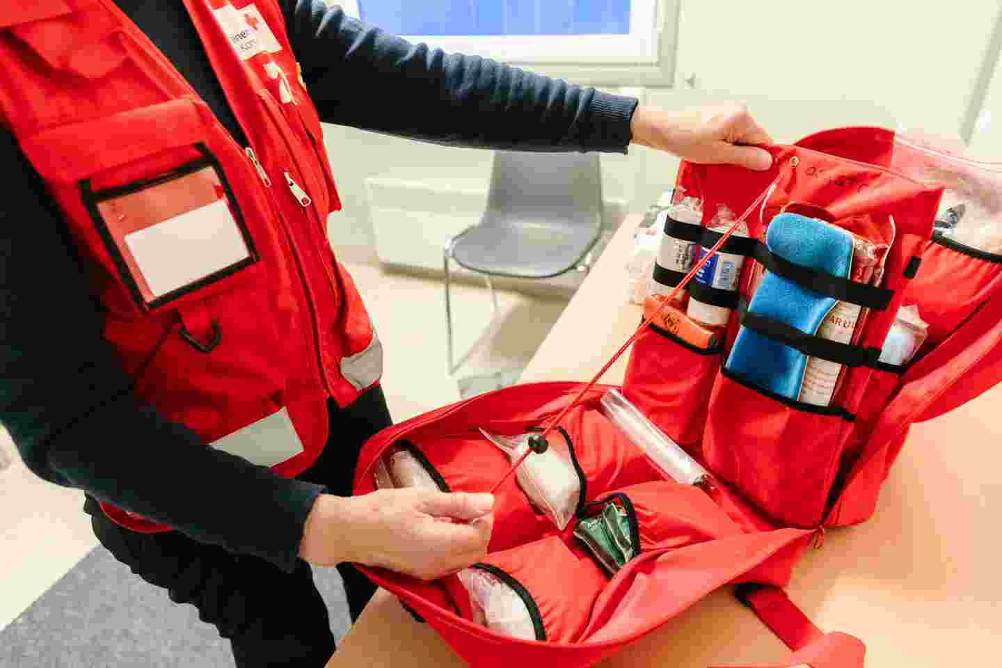 A Red Cross volunteer with an open first aid case.
