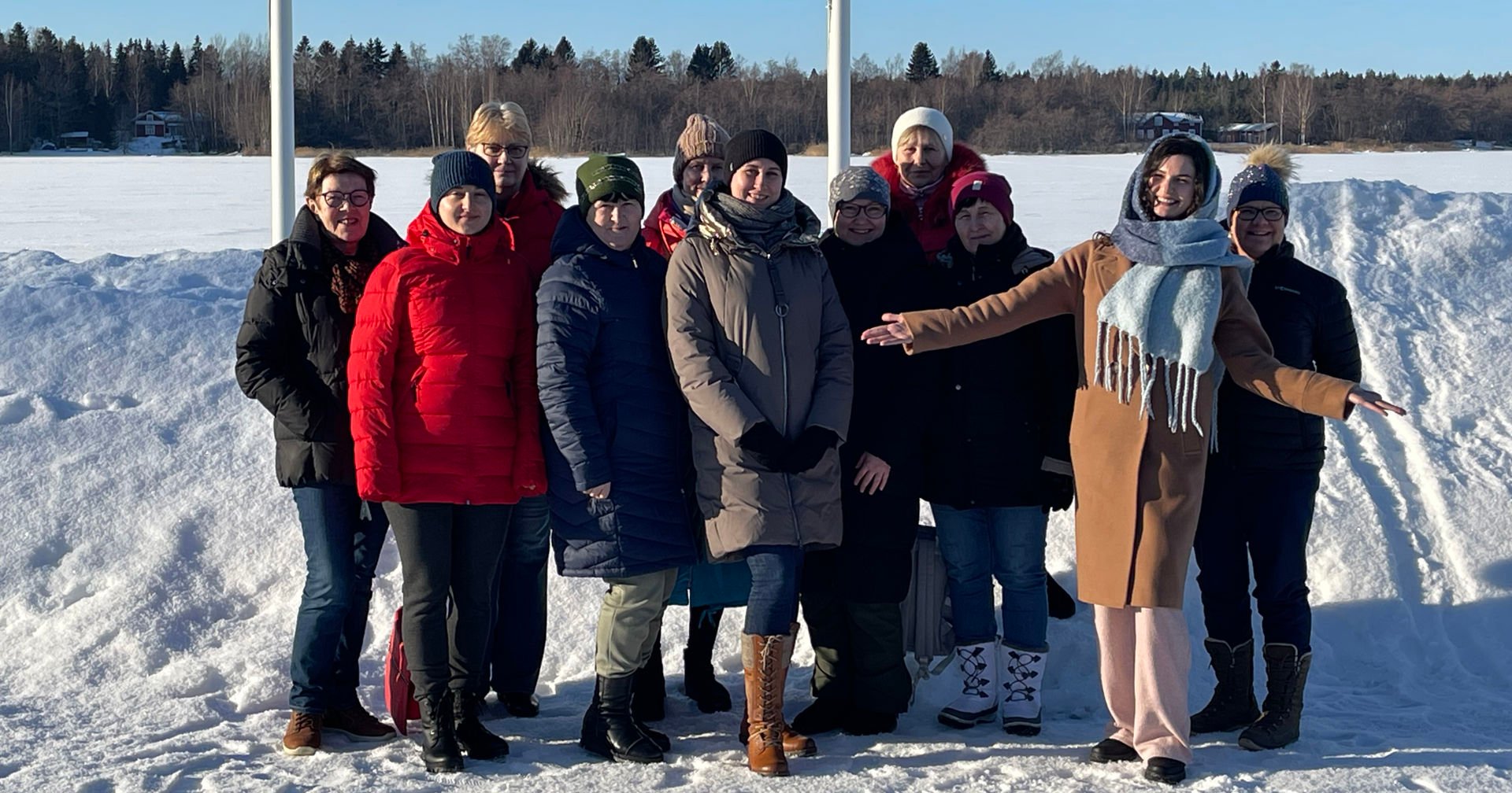 Red Cross volunteer and participants of the Red Cross course in Ukrainian smiling together outdoors in the winter.